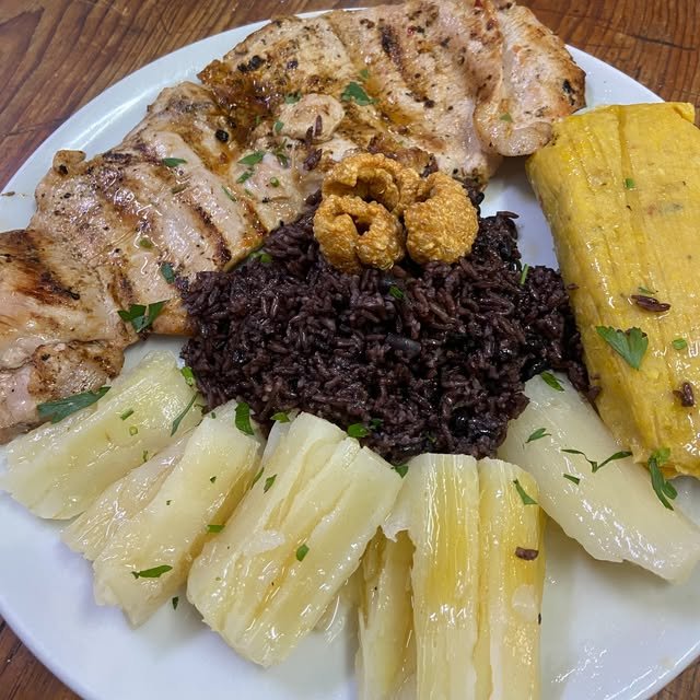 Pollo a la brasa con arroz negro, yuca y millo